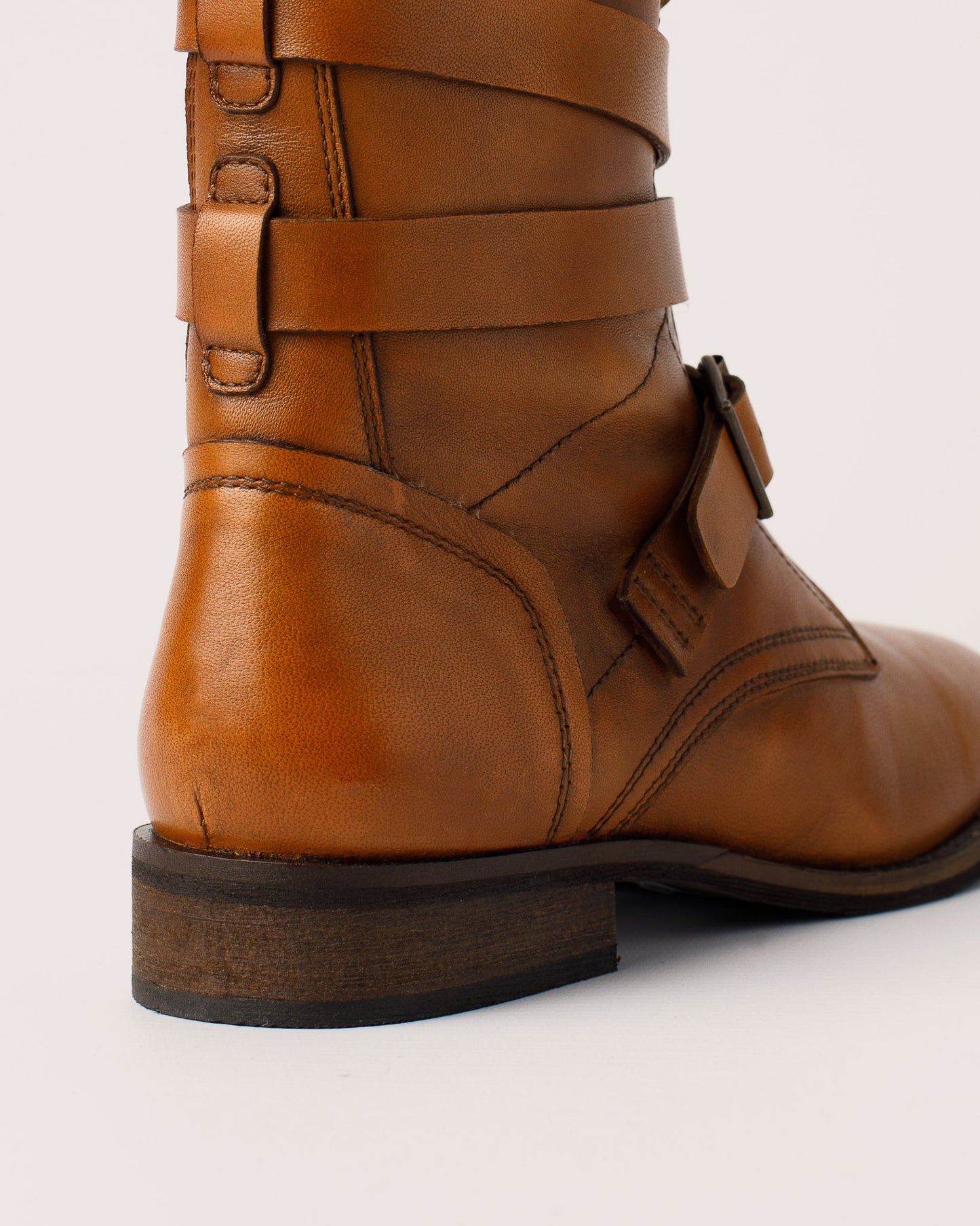 Detail of leather buckle strap design on Courtney cognac boots