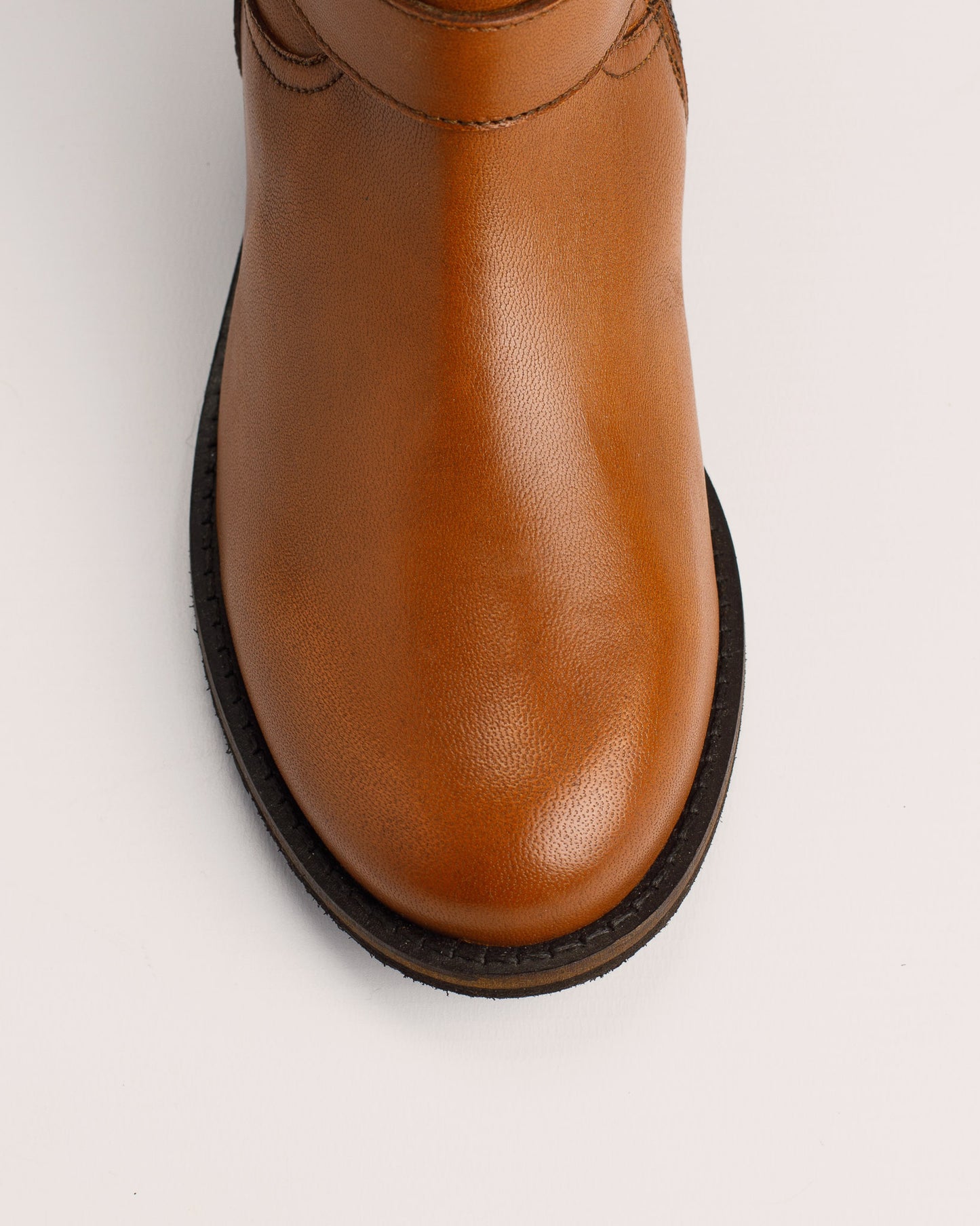 Detail of cognac leather texture and buckle on Lisa ankle boots