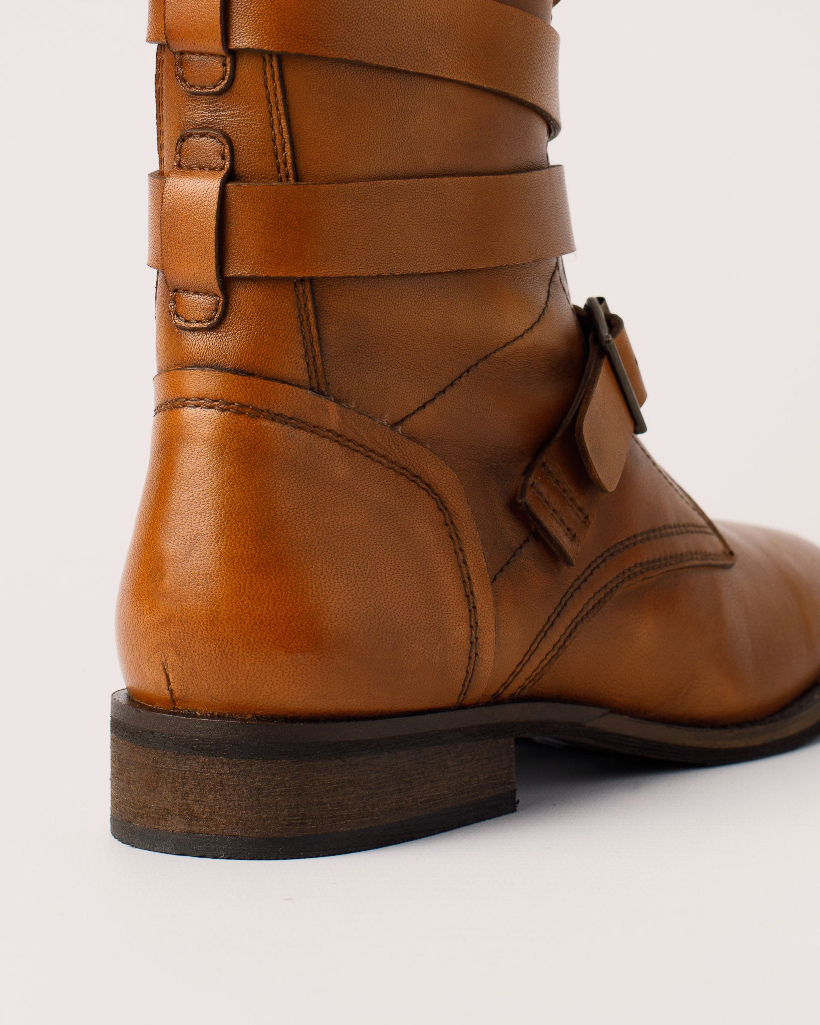 Detail of leather buckle strap design on Courtney cognac boots